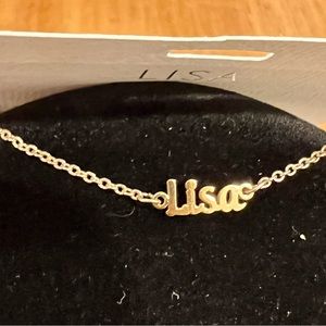 in sealed package, gold tone Lisa necklace. Petite name on gold chain- stackable